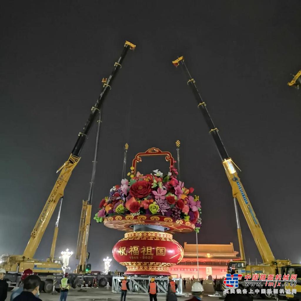 夜色笼罩下的京城祥和而神秘，数台熠熠生辉的徐工起重机和高空作业车组成金色车队，从正阳门前宽阔的大道上庄严驶入天安门广场。