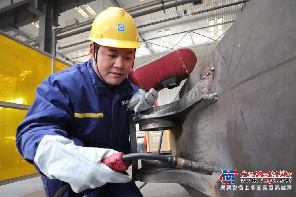 	他身材壮硕、步履坚定，厚实的手掌中，隐约可见老茧和裂纹；他性格开朗、侃侃而谈，温厚的笑容里，饱含着对岗位的热爱和未来的期待。他常说“工作是踏踏实实干出来的。”十载光阴，奋斗如歌，他就像一颗永动的齿轮，扎根徐工、心无旁骛，以青春燃烧激情，用匠心打造精品。他，就是徐工挖掘机械事业部结构二厂大挖工作装置工段焊工李容强。