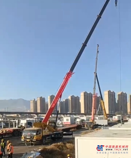 	12月23日，在甘肃省积石山县大河家镇的临时安置点上，吊装人杨祥正在卸载一车车紧急拉来的板房。